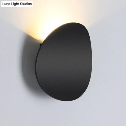 Modern style black matte wall sconce with oval shape and warm focused led light for bedroom use