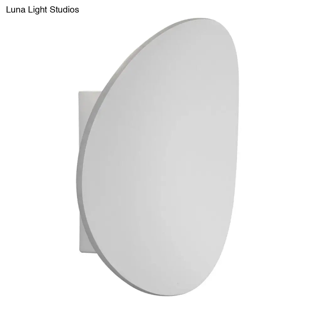 Modern white and black wall sconce with a sleek minimalist oval design for bedroom lighting in modern style