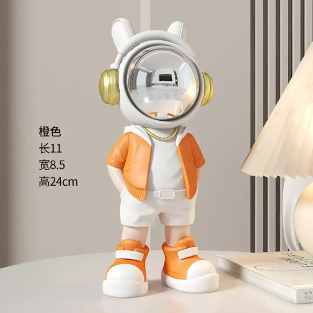 Modern white and blue astronaut resin sculpture featuring an orange and white astronaut figurine with gold headphones