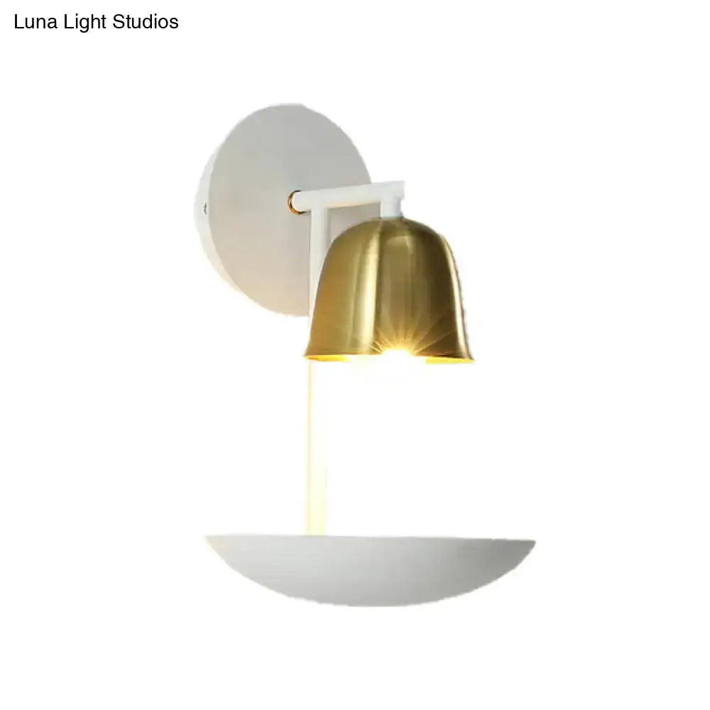 Modern white and brass bell metal sconce with polished brass shade and white matte metal mounting plate for bedroom walls