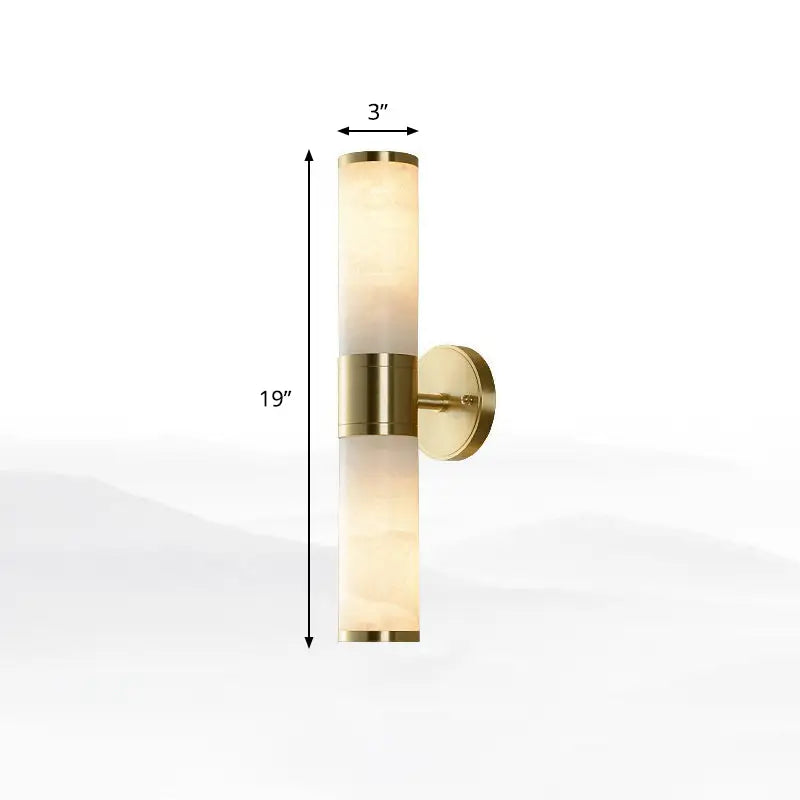 Modern white and brass pillar shaped sconce light with alabaster shade and brushed brass accents bedside wall lamp