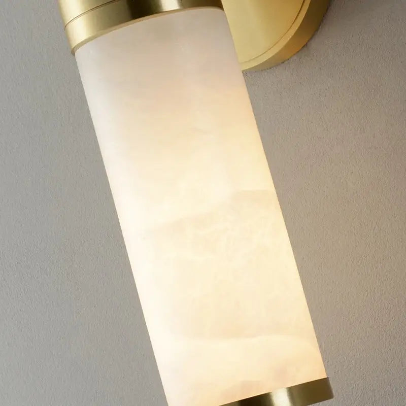 Modern white and brass pillar shaped sconce light with alabaster glass shade for bedside wall lamp use