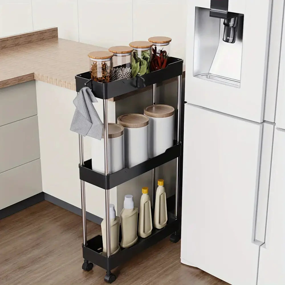 Black three-tiered kitchen cart with stainless steel legs and wheels holding canisters as a bathroom storage rack