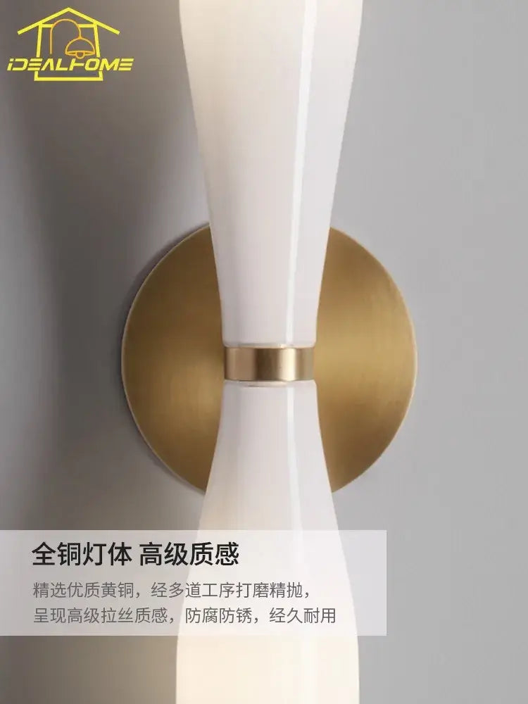 Modern white and copper wall lamp featuring a white ceramic sconce with gold-toned brass base for bedroom decorbites