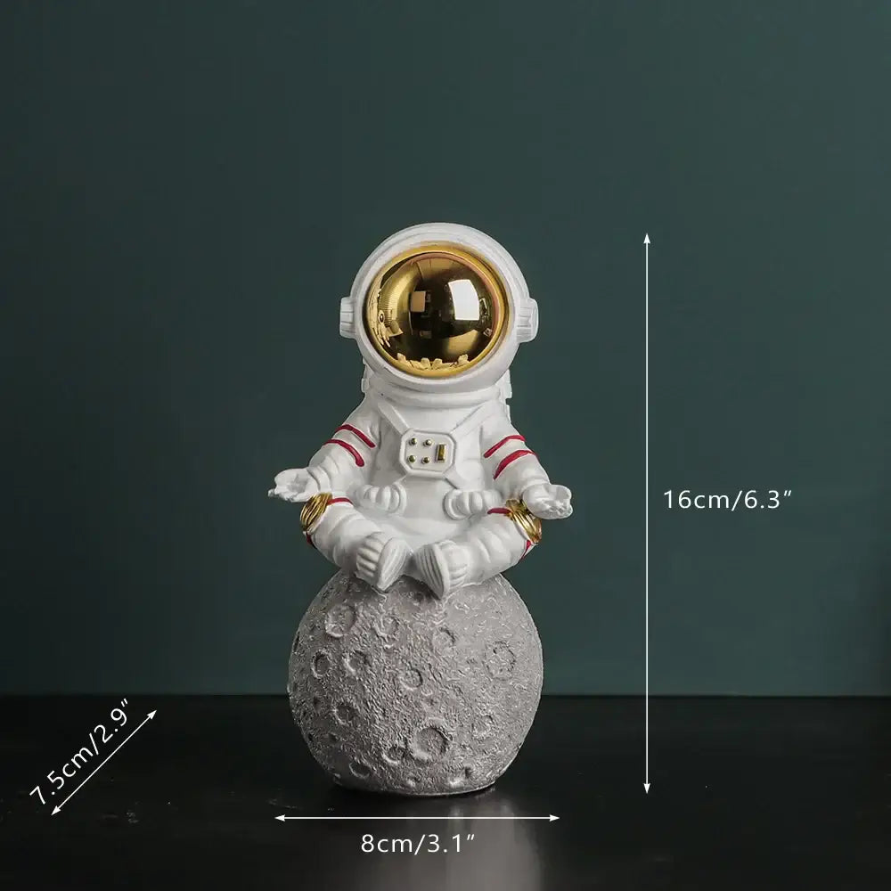 Modern white astronaut figurine with electroplated golden visor and red stripes meditating on textured gray moon surface