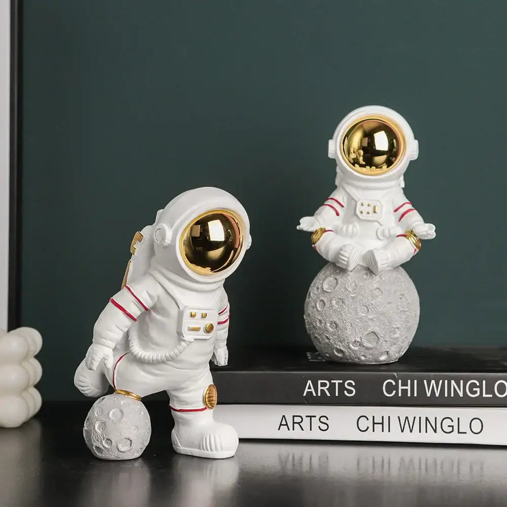 Modern white astronaut figurines with electroplated golden visors and red trim for living room decor on moon spheres