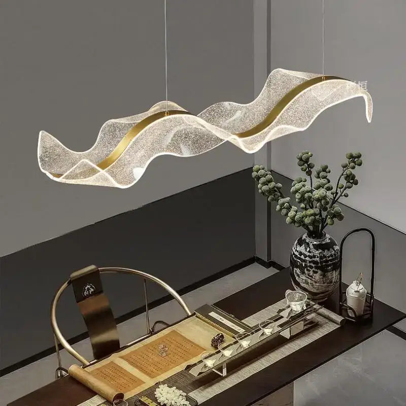 A modern white and gold decorbites acrylic ribbon led pendant with a wave-shaped translucent textured body for dining room light