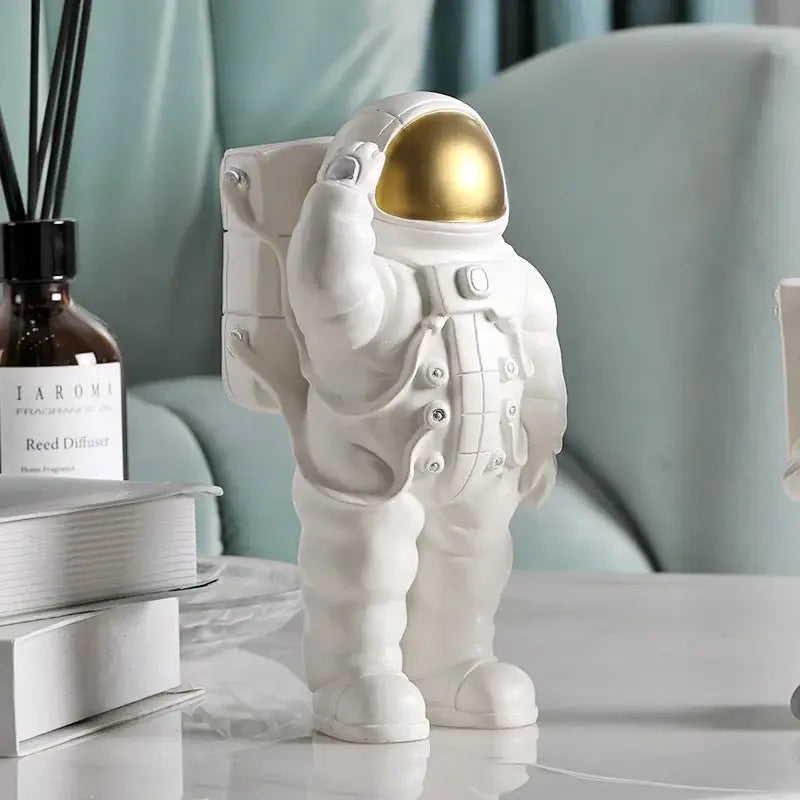 Modern white and gold astronaut phone holder figurine in white with gold helmet standing on a table for decorbites astronaut phone decor