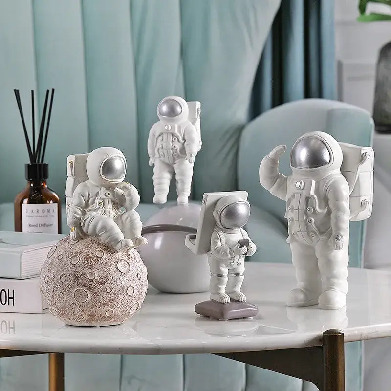 Modern white and gold astronaut phone holder with silver helmets and detailed suits on marble table decorbites astronaut phone holder