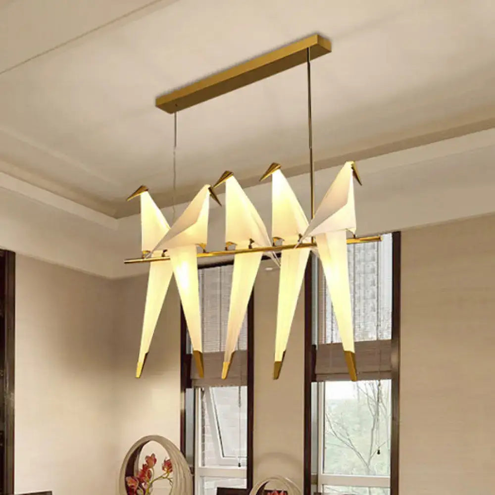 Modern DecorBites™ gold-toned bird shaped island pendant light with four illuminated origami style birds for bedroom