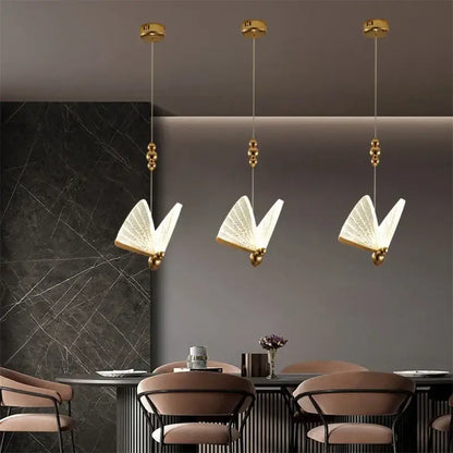 Three elegant gold-toned decorbites butterfly pendant lights with translucent illuminated wings for bedroom decor