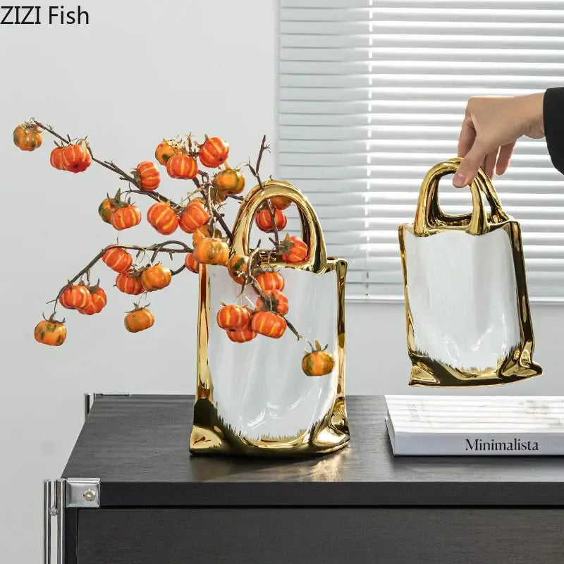 Modern white and gold handbag ceramic vase with a glossy interior filled with orange pumpkin branches decorbites golden handbag