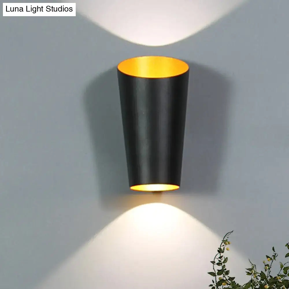 Black and gold cylindrical wall light with a sleek modern led design perfect as a bedside sconce for bedroom use