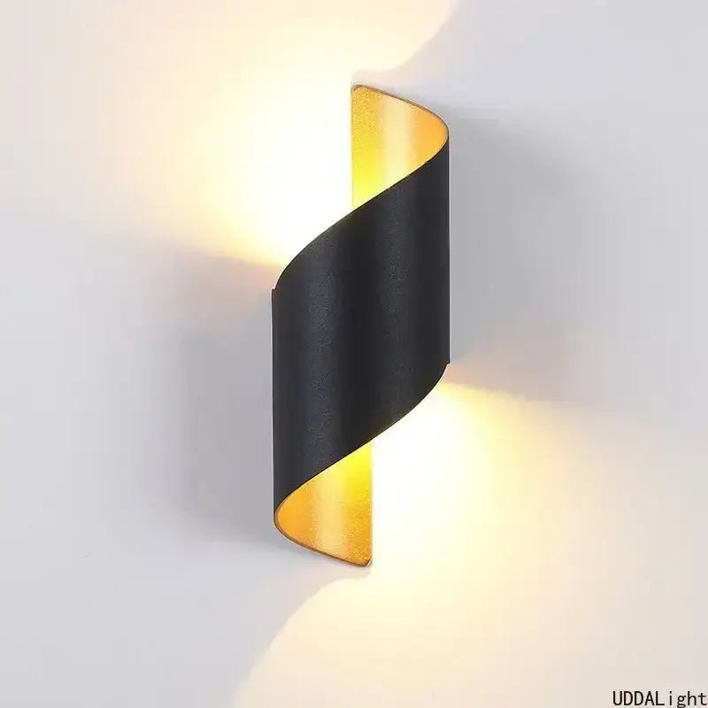 A sleek black and gold spiral outdoor wall lamp with a modern twisted design for patio lighting