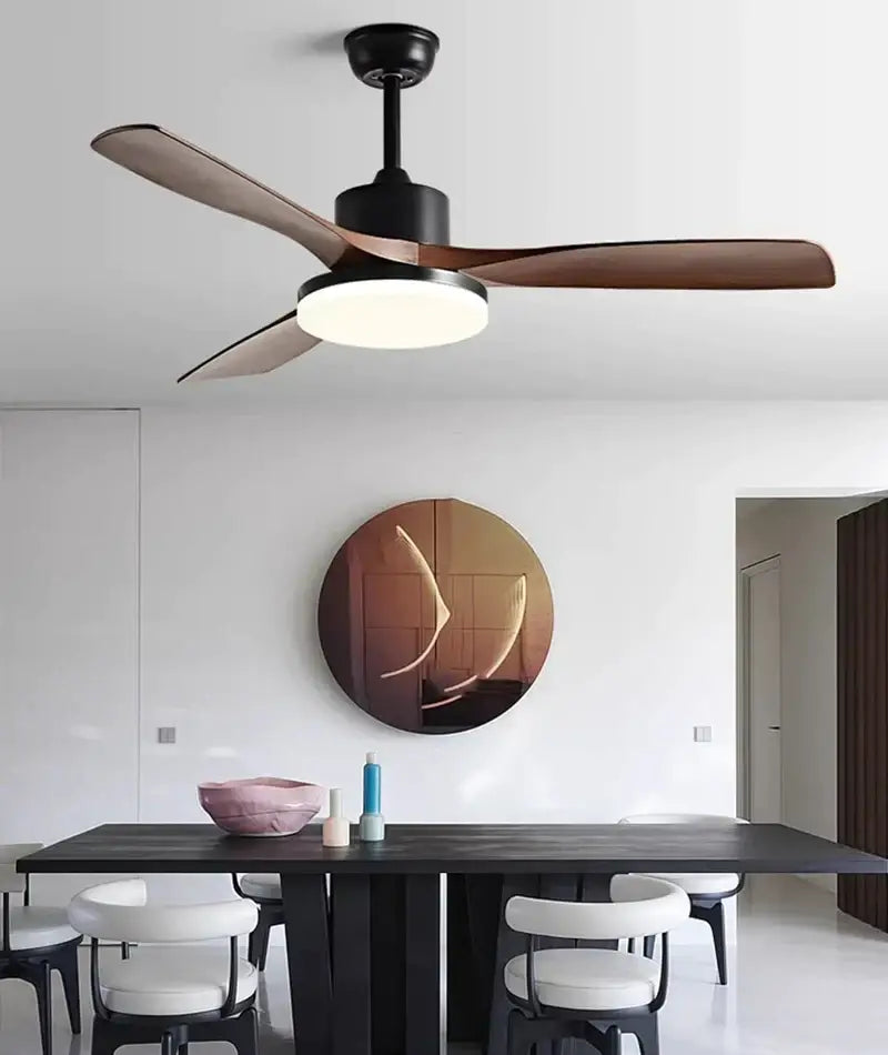 Modern ceiling fan with sleek black housing, rich brown wooden blades, and integrated circular LED light fixture for bedroom