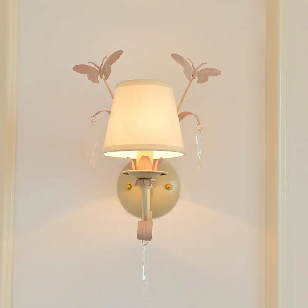 Modern white finish wall lamp with pink metal butterfly accents and cream fabric shade for home décor bedroom use