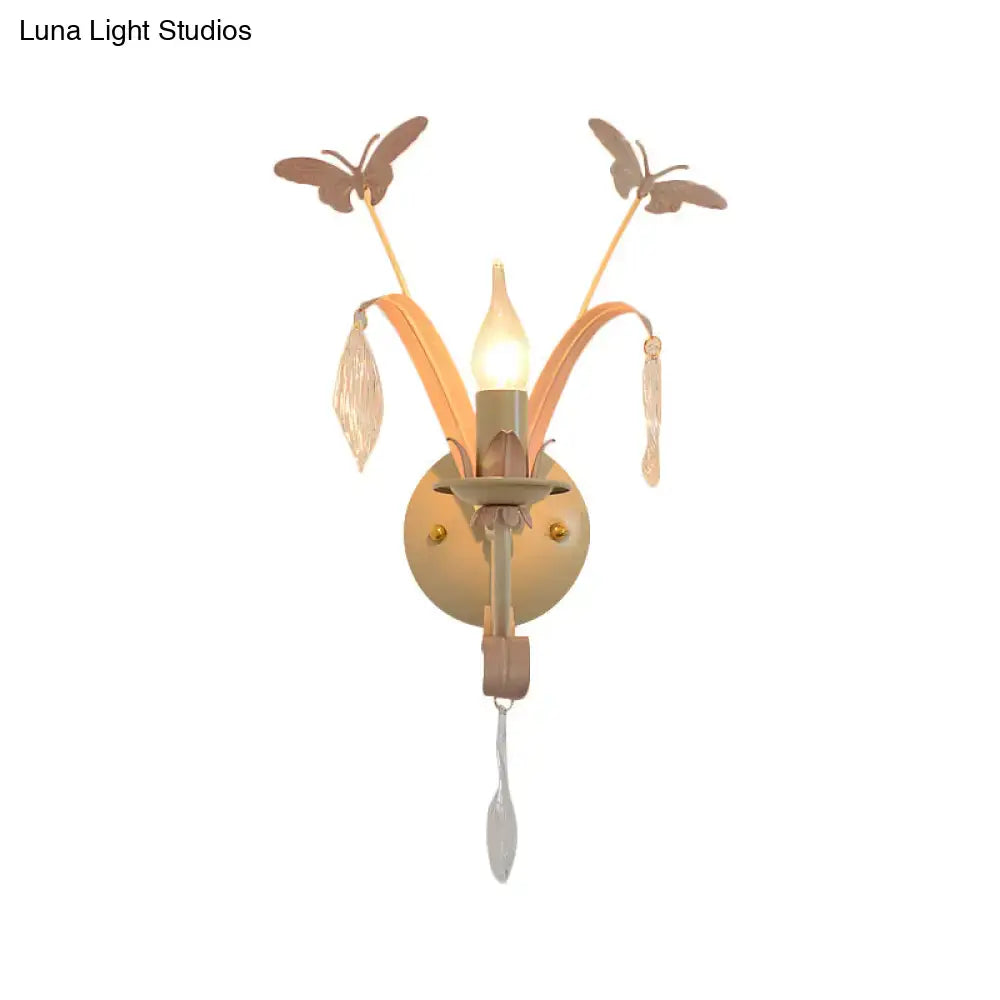 Antique brass wall lamp with white finish, butterfly and leaf accents, crystal droplets, and candle-style bulb for home décor
