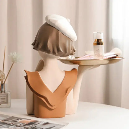 Ceramic balloon girl bust sculpture in white beret and tan ruffled top holding a gold-trimmed tray for living room decor