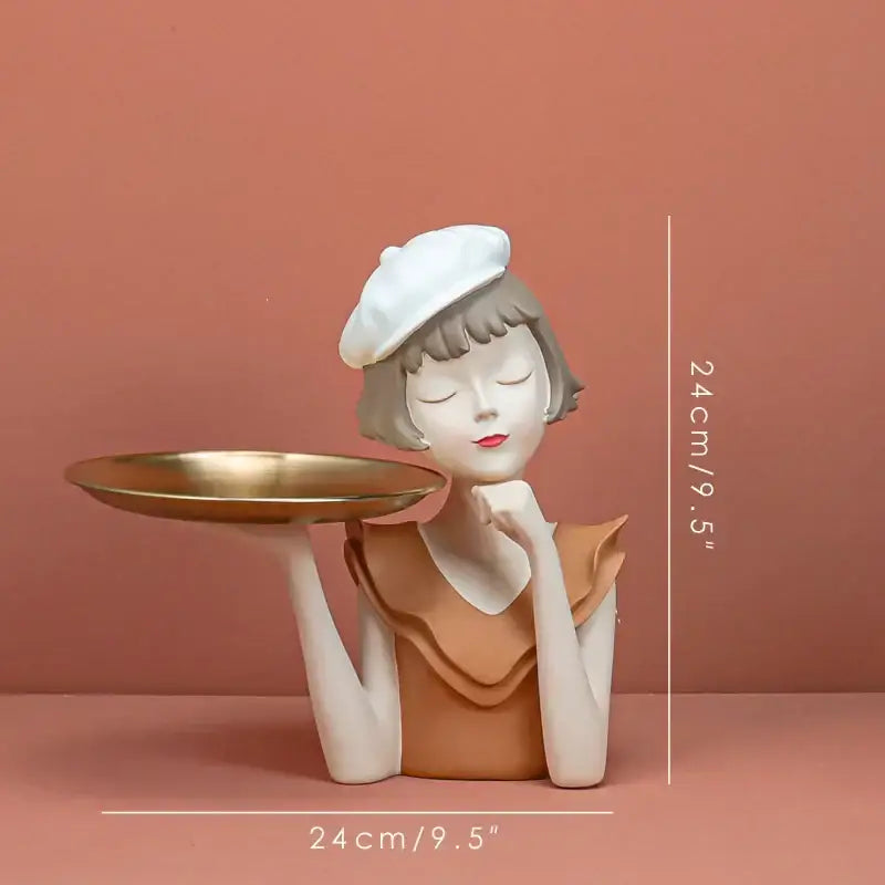 A modern white and tan resin balloon girl bust tray sculpture of a woman in a beret holding a gold tray for living room