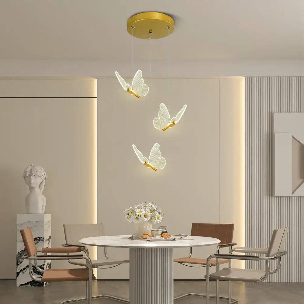 Modern white and warm gold pendant light with butterfly-shaped translucent wings and warm gold finish for bedrooms