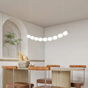 Modern white bead nordic chandelier with spherical bulbs arranged in an elegant curved line for dining room use