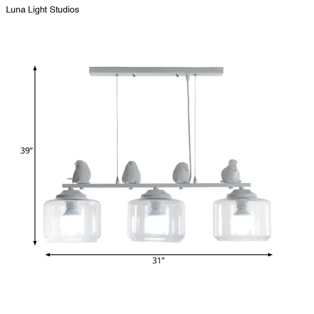 Modern gray bird-themed island lighting fixture with three clear glass shades and sleek metal frame for dining room
