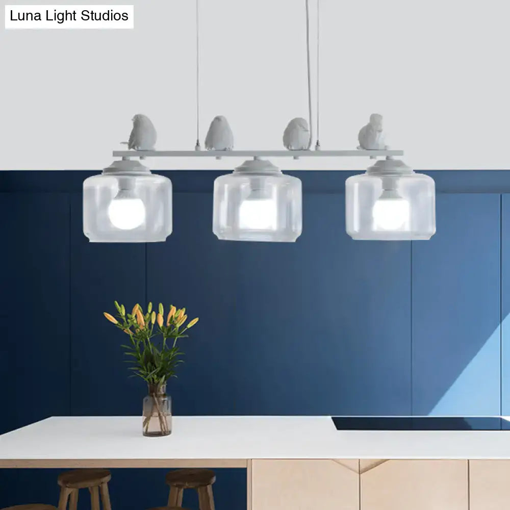 Modern decorbites island lighting fixture with four clear glass shades and gray bird figurines for dining room use