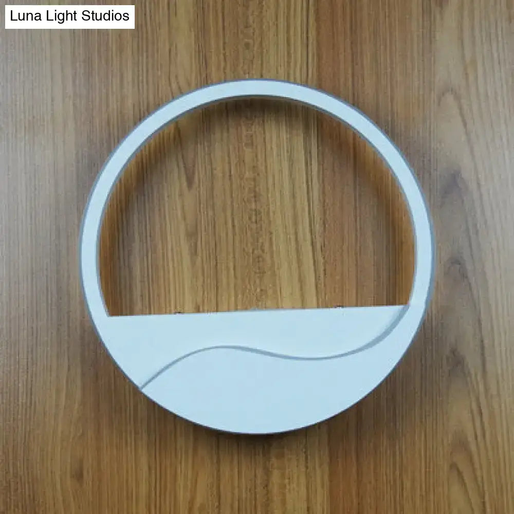 Modern white acrylic wall sconce with circular minimalist design and warm white light for bedroom use