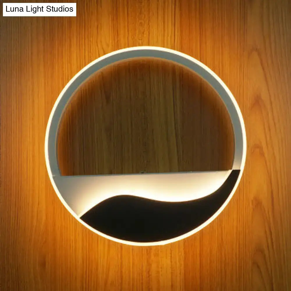 Modern white and black acrylic wall sconce with a sleek frame and warm white light for bedroom ambient lighting
