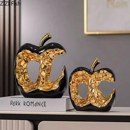 Modern white and black ceramic apple sculpture with glossy black and gold finish ideal for desk decoration and living room decor