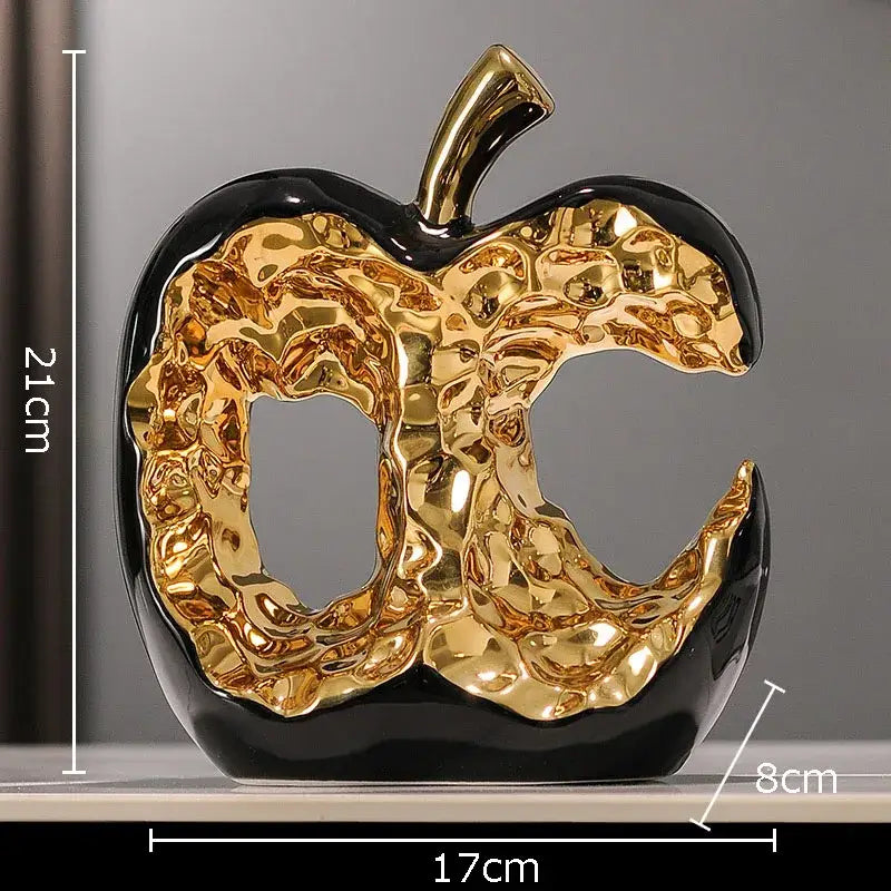 Glossy black and gold ceramic apple sculpture with textured metallic interior for modern desk decoration