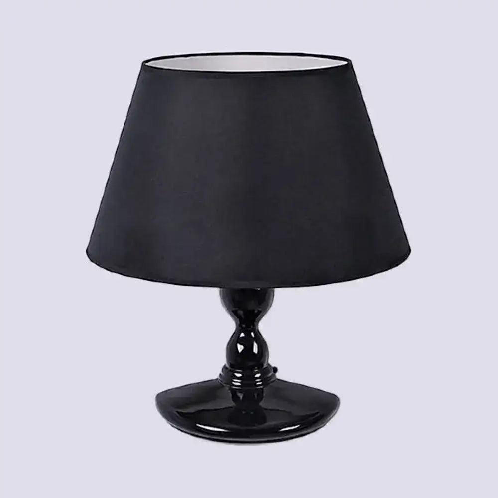 Black ceramic table lamp with glossy finish and matching black fabric shade for modern white black cone decor