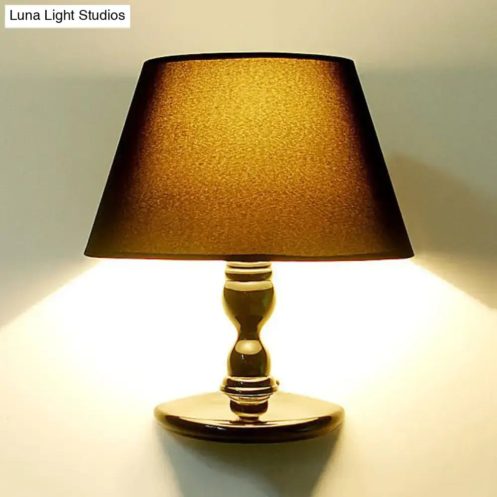 Gold-finished table lamp with textured warm amber shade complementing modern white black cone ceramic wall sconce bedroom light