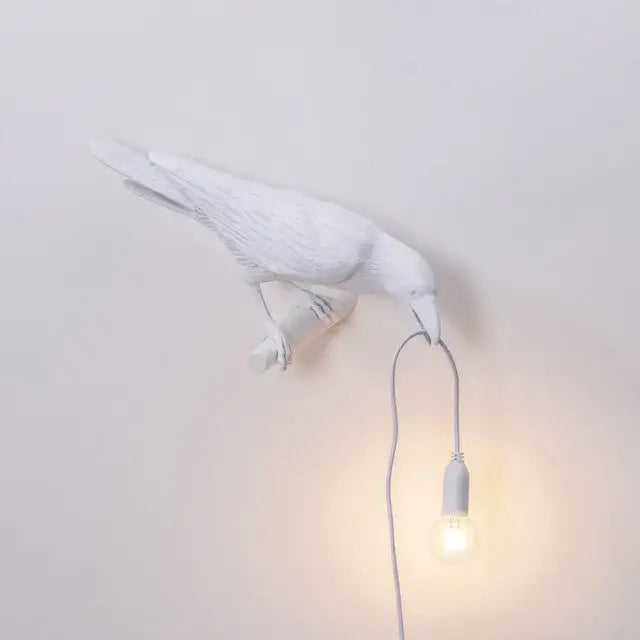 Modern white ceramic wall lamp with single exposed bulb hanging from beak decorbites designer bird wall lamp