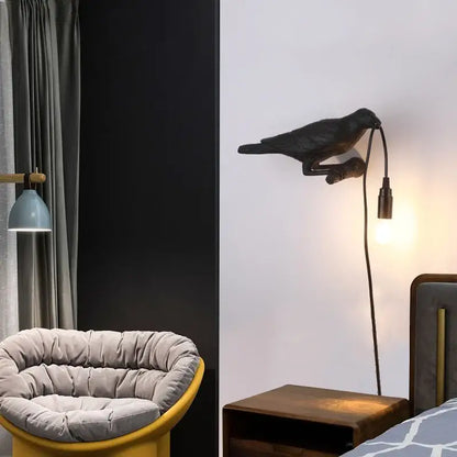 Black crow-shaped wall lamp with curved neck and extending cord by decorbites designer bird for bedroom use