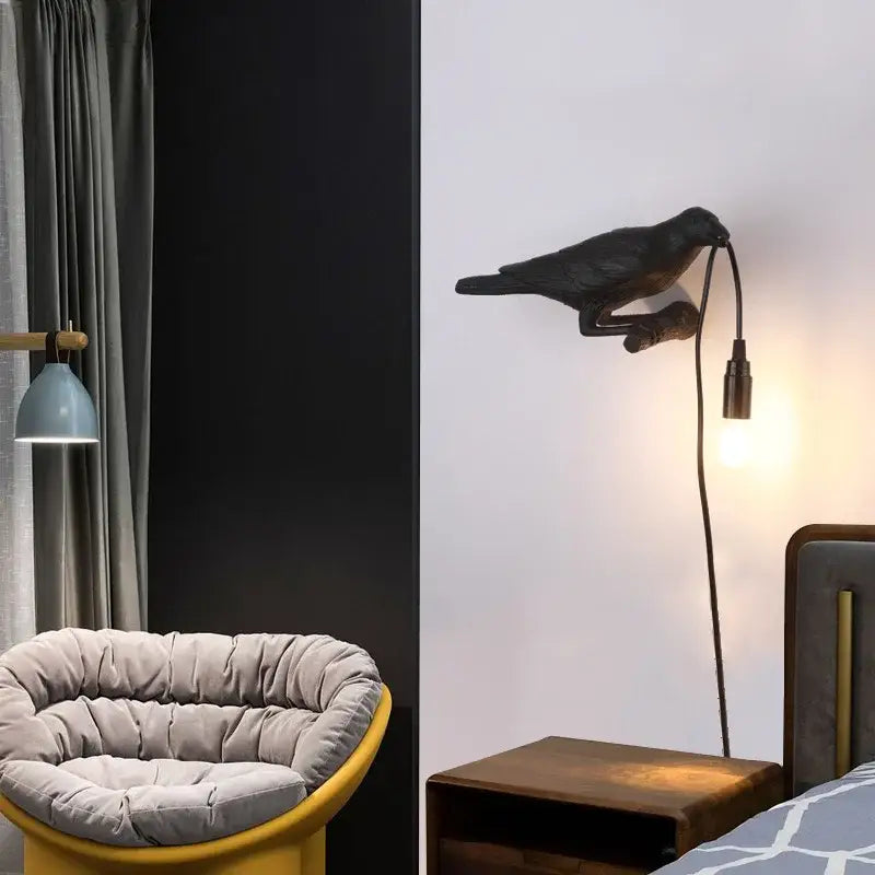 Black crow-shaped wall lamp with curved neck and extending cord by decorbites designer bird for bedroom use