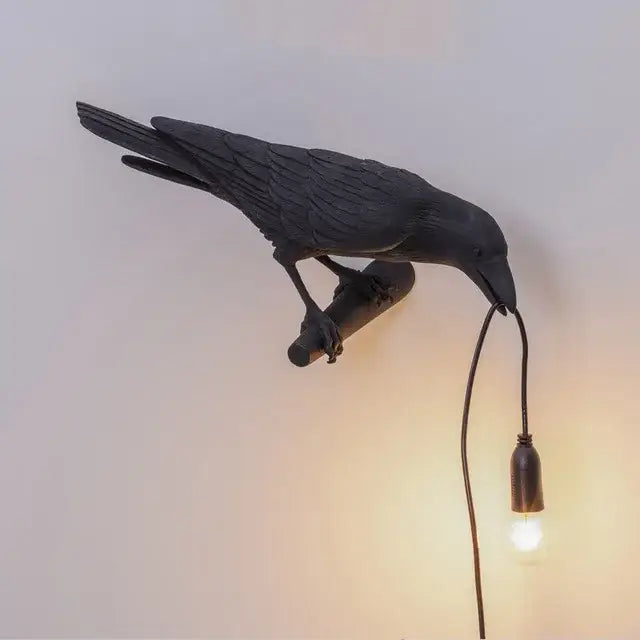 Modern white and black decorbites designer bird wall lamp featuring a black crow with textured feathers and exposed bulb
