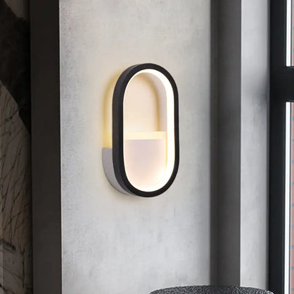 Modern white and black ellipse led wall lamp with sleek black frame and warm white illuminated interior for bedroom use