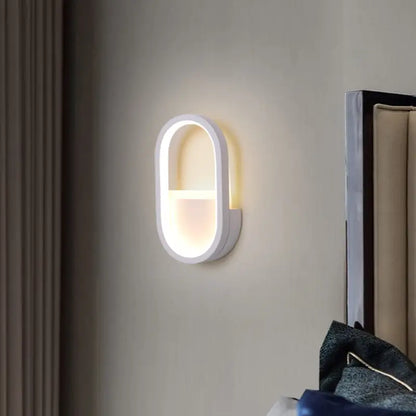 Modern white oval wall lamp with black ellipse frame featuring warm white led light for bedroom use