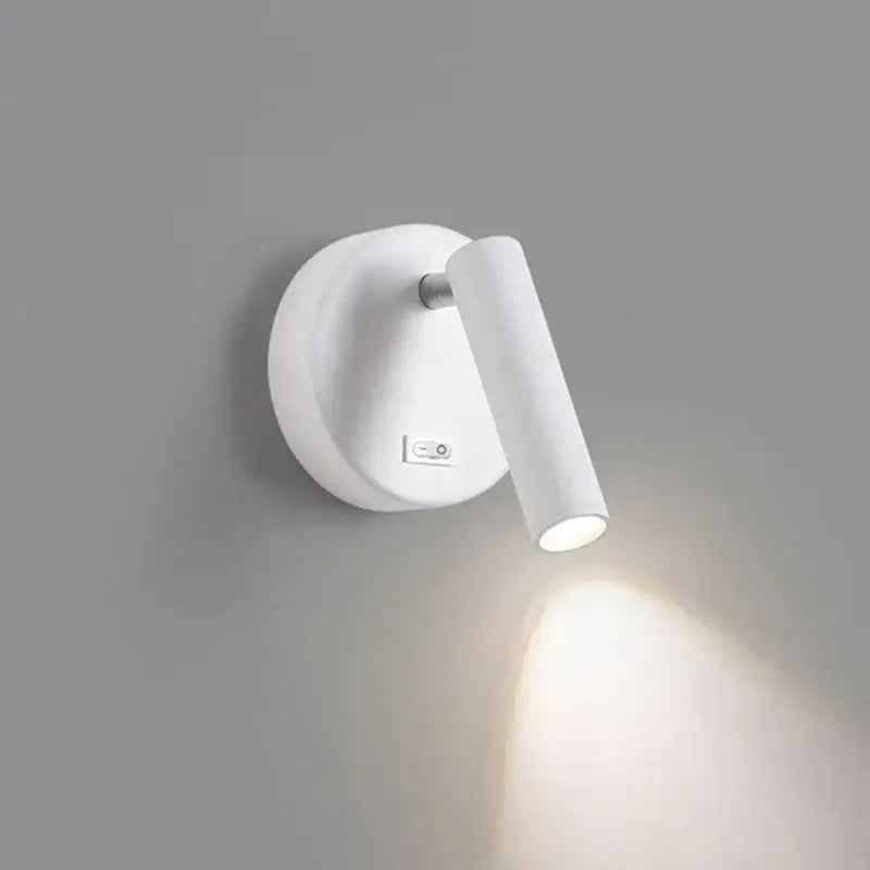Modern white and black led wall lamp with sleek cylindrical head and circular base for bedroom reading light