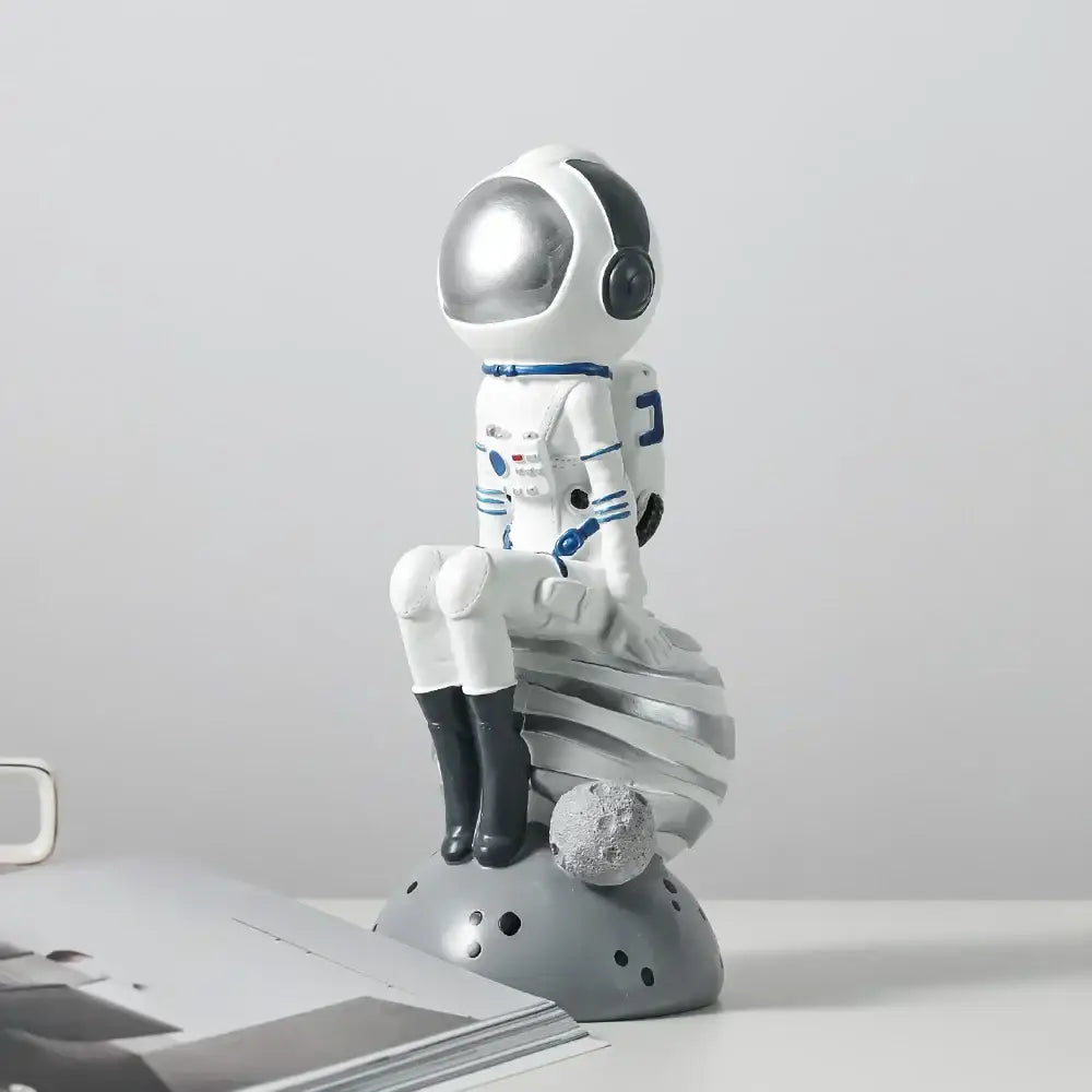 Modern white and blue astronaut resin figurines with silver helmet seated on gray moon base for living room decorbites astronaut resin