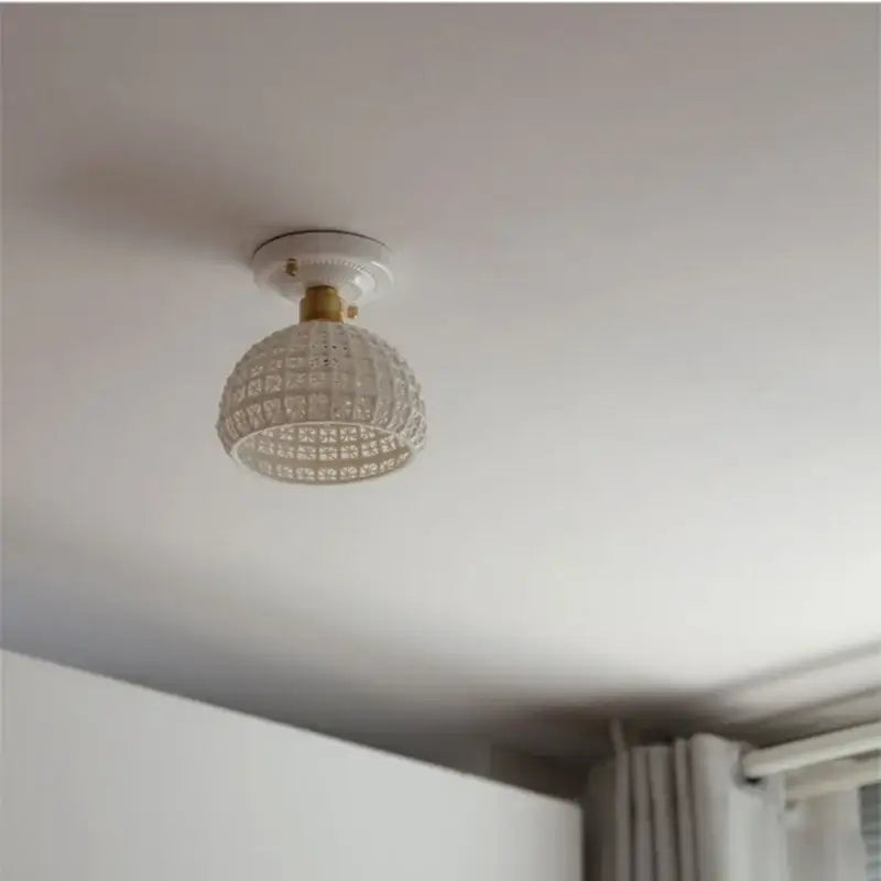 Modern white and brass ceramic led ceiling lamp featuring a textured glass globe and brass-finished mounting base