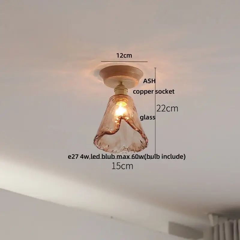 A warm-toned hand-blown glass pendant light with copper socket and ash wood base for modern ceramic led ceiling lamp use