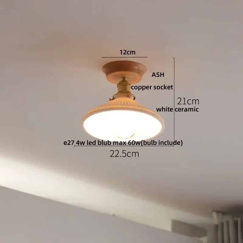 A warm-toned modern white and brass ceramic led ceiling lamp with wooden base and copper socket for bedroom lighting