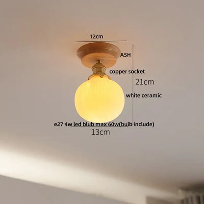 A warm glowing white ceramic led ceiling lamp with brass copper socket and ash wood mount for bedroom use