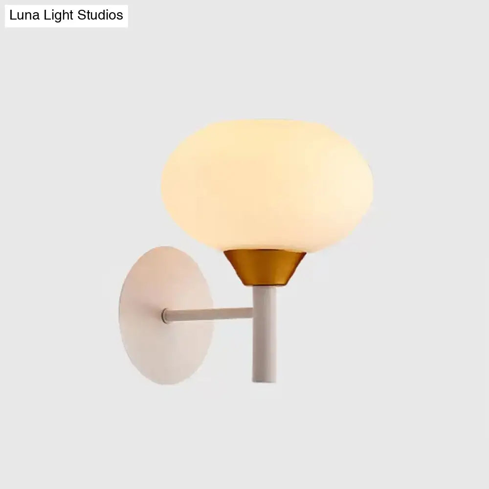 Modern white and brass wall sconce with frosted opal glass globe on a matte white backplate 220v-240v bedroom light