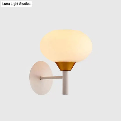 Modern white and brass wall sconce with frosted opal glass globe on a matte white backplate 220v-240v bedroom light