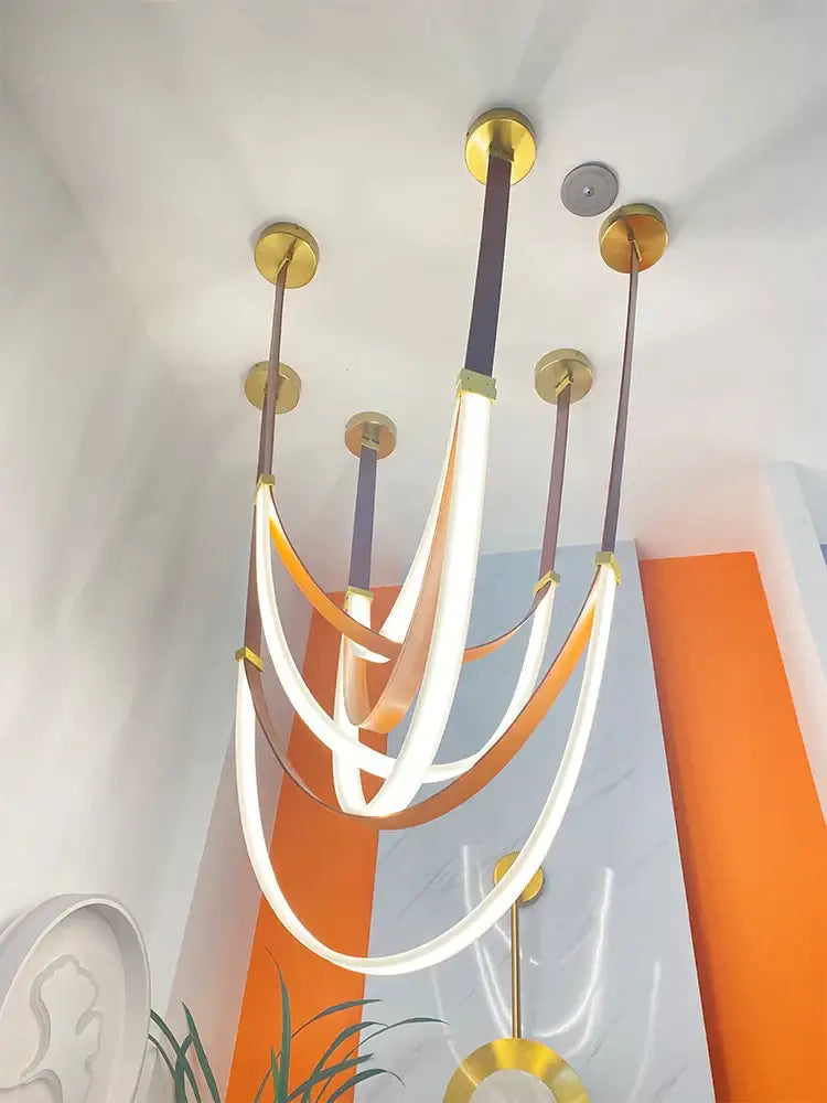Modern white and brown designer villa chandelier with curved glowing led strips and gold-toned metal by decorbites designer villa