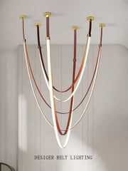 Modern white and brown leather chandelier with curved illuminated belt pendant light suspended from gold fixtures