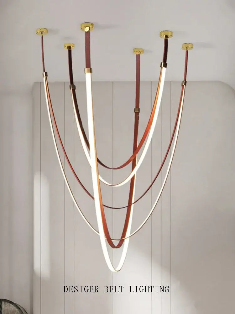 Modern white and brown leather chandelier with curved illuminated belt pendant light suspended from gold fixtures